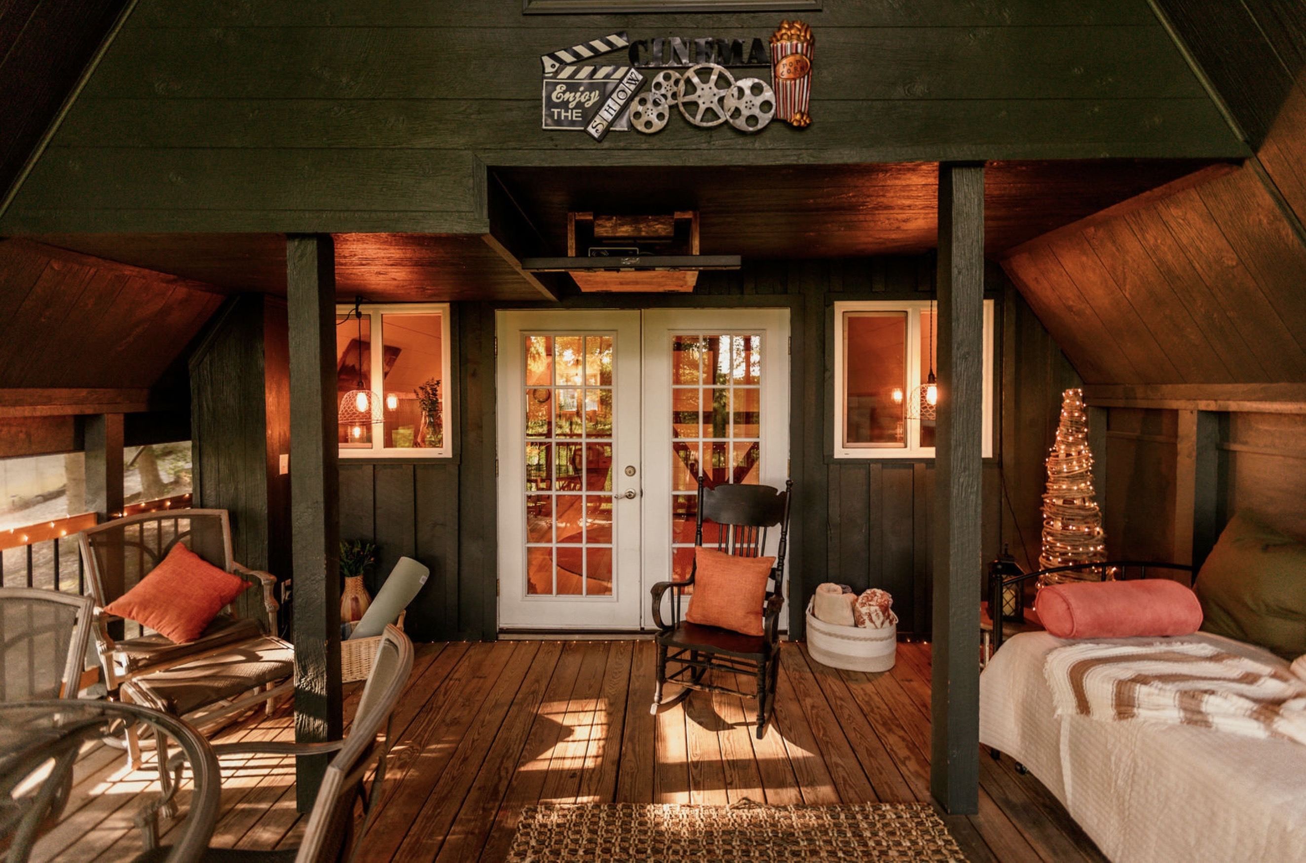 Canyon Ridge Retreats screened cinema porch exterior with warm evening lighting and Cinema sign
