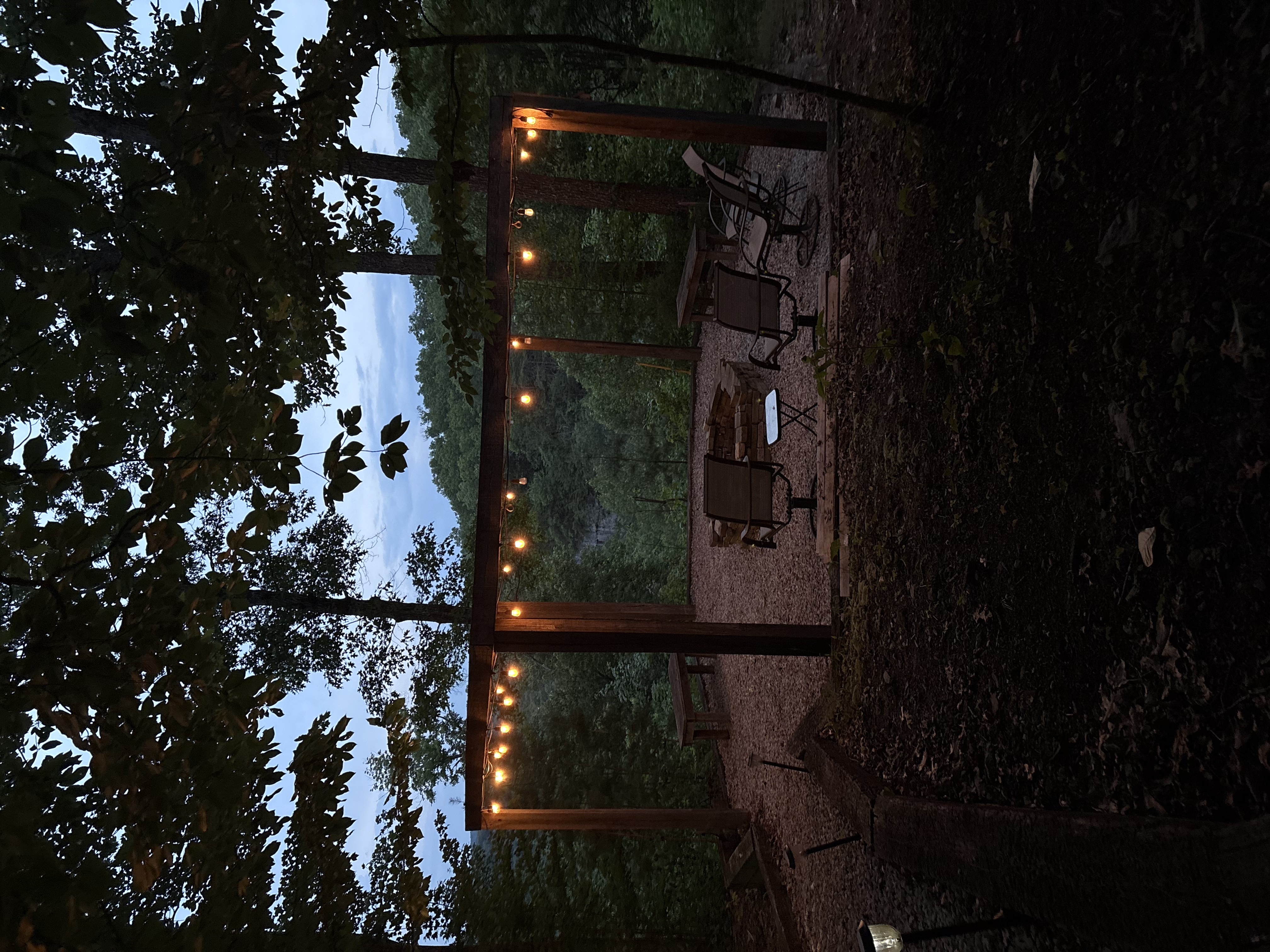 Canyon Ridge Retreats fire pit at dusk with string lights and canyon cliff view